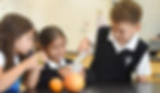 Three elementary school students conduct a science experiment using acids from citrus. Saint Nicholas Catholic School has a large, fully equipted science lab..
