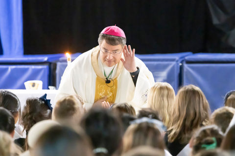 The Bishop of San Jose listening intently to a student at Saint Nicholas Catholic School during the annual Bishop's mass.