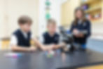 Three fifth grade use a microscope and recording their findings in the science lab at Saint Nicholas Catholic School