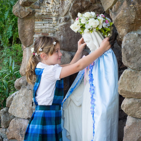 A kindergartener crowns Mary at Saint Nicholas Catholic School's annual May Crowning ceremony