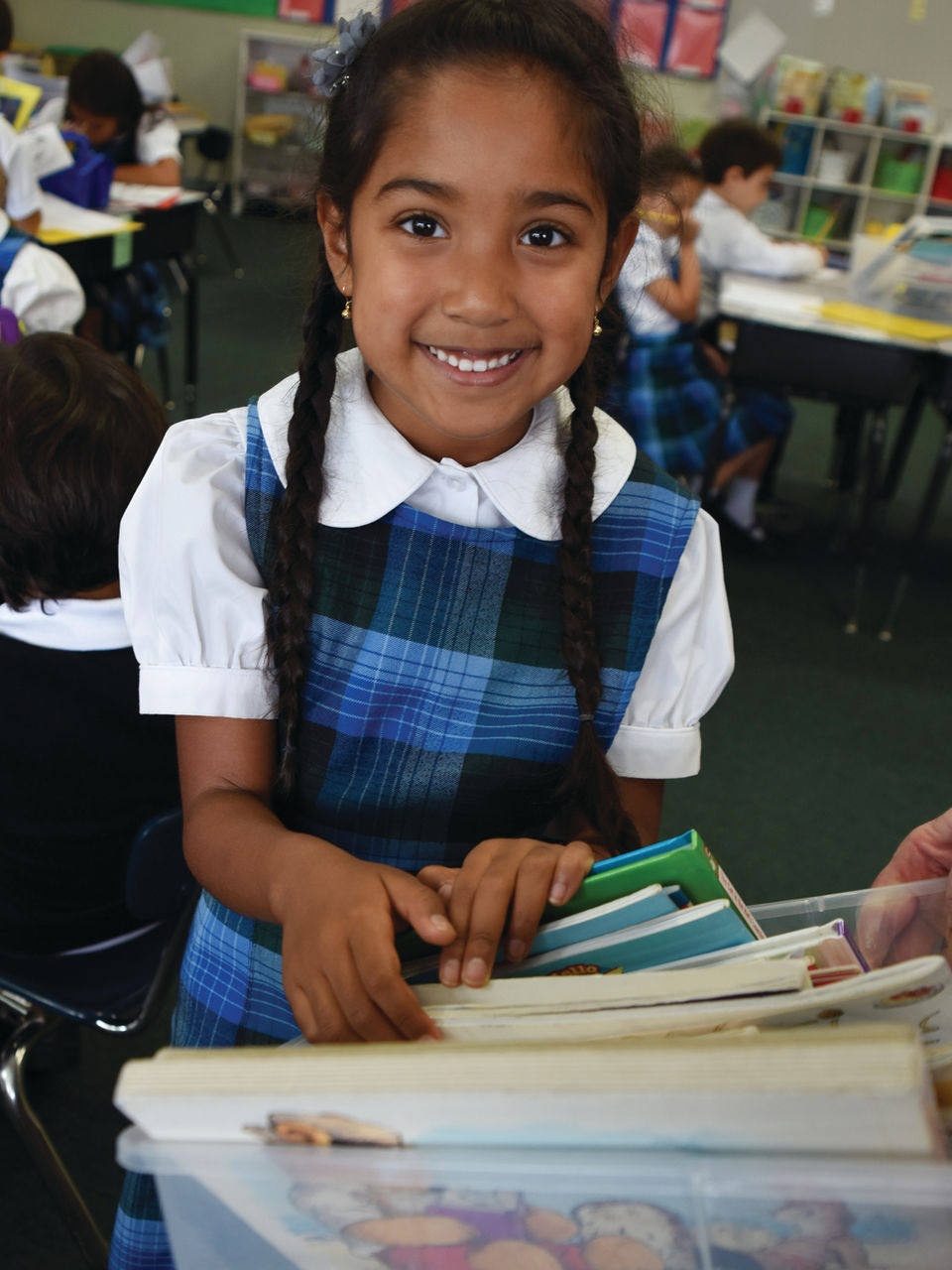 A link to the Saint Nicholas Catholic School About Us page opens. The image depicts an elementary school student looking through a bin of books at Saint Nicholas School in Los Altos Hills CA.