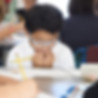 This image links to the Saint Nicholas School Capital Campaign page. It depicts an elementary school student at Saint Nicholas Catholic School working at his desk. 