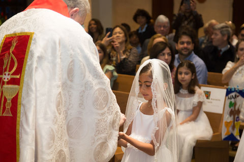 A second grader student from Saint Nicholas Catholic School makes her First Communion.