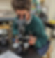 A link to the Saint Nicholas Catholic School High School Acceptances Page. The image shows a male student in middle school looking into a microscope in the science lab